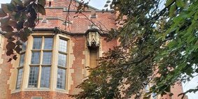 The red-brick exterior of 43 Woodland Road, the department building, with trees in the foreground.