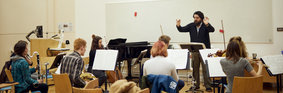 Group of music students with a range of instruments rehearsing. 