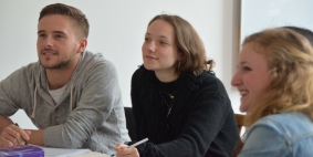 One man and two women sat together, smiling.