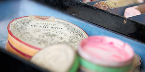 Some circular make-up containers in a tray.